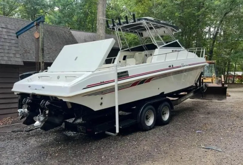 Slide: The Image of 1996 Fountain 32 Sportfish Cruiser IO on trailer in wooded area. - 1