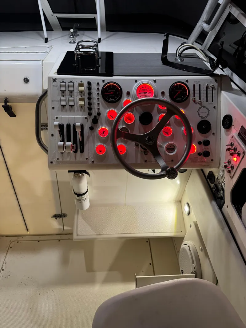Slide: The Image of 1996 Fountain 32 Sportfish Cruiser IO dashboard with illuminated gauges and controls. - 11