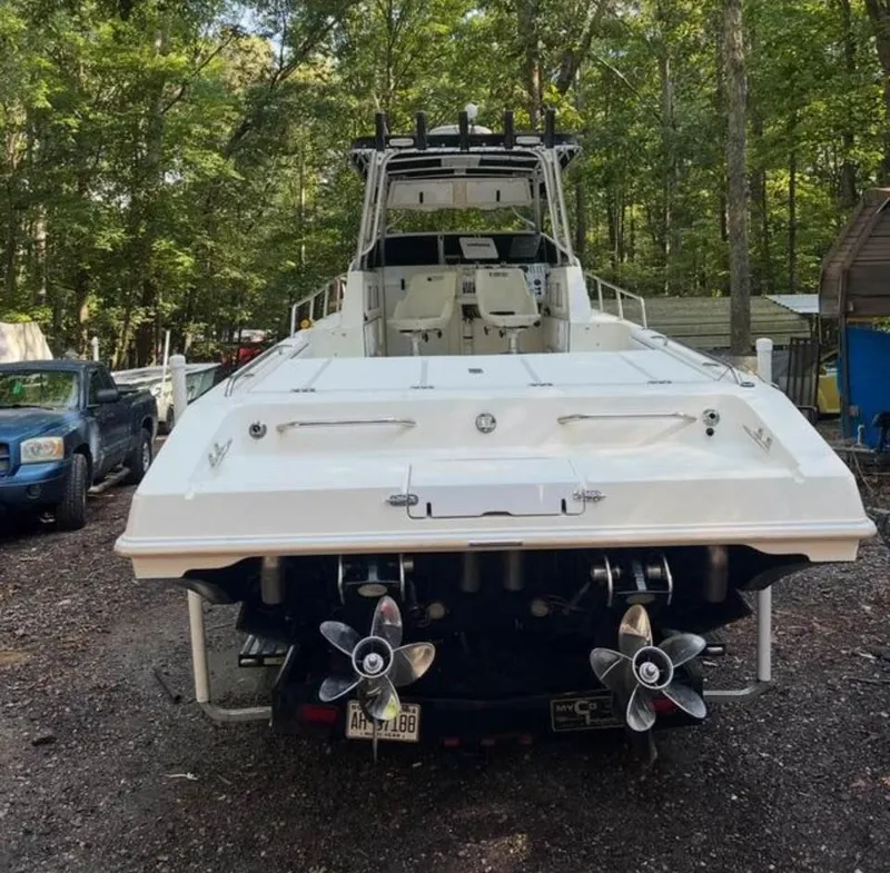 Slide: The Image of 1996 Fountain 32 Sportfish Cruiser IO boat with dual propellers in wooded area. - 2