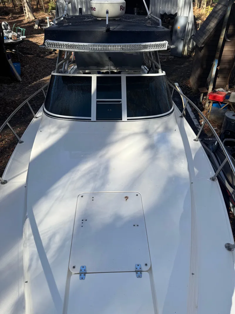 Slide: The Image of 1996 Fountain 32 Sportfish Cruiser IO boat, top view, white deck, outdoor setting. - 3