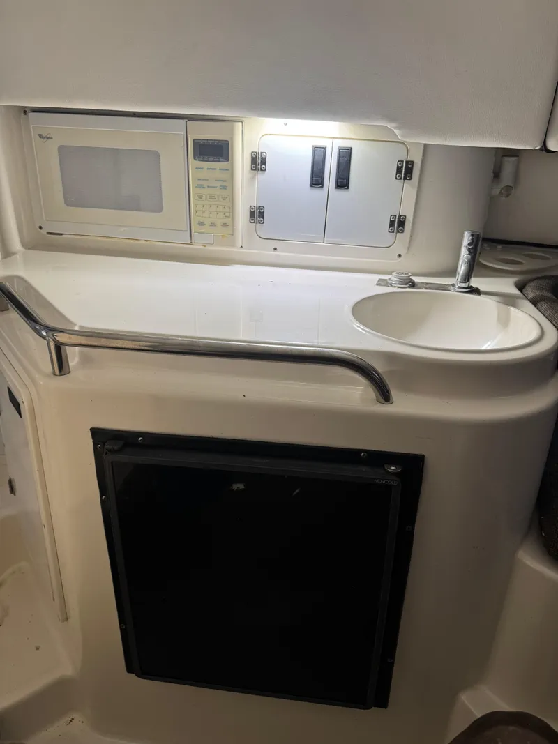 Slide: The Image of 1996 Fountain 32 Sportfish Cruiser IO interior kitchenette with sink and microwave. - 8