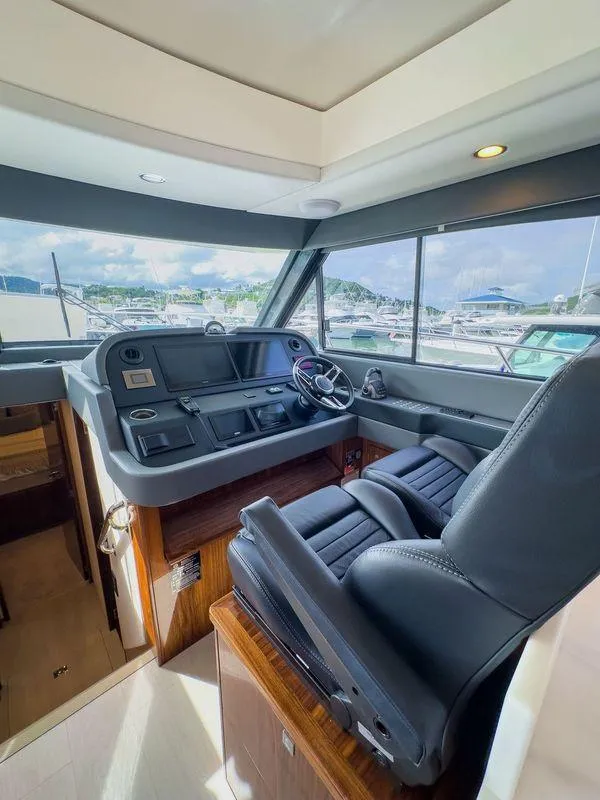 Slide: The Image of 2024 Riviera 465 SUV helm with luxurious seating and panoramic marina view. - 14