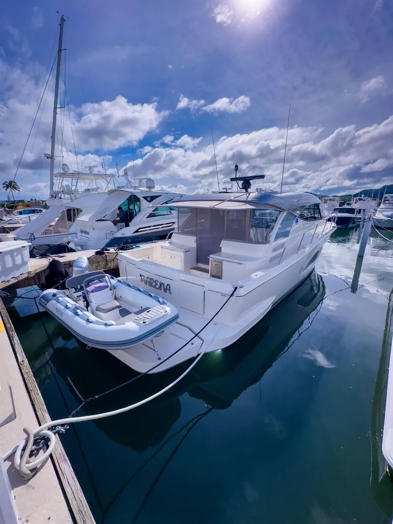 Slide: The Image of 2024 Riviera 465 SUV yacht docked at marina under a sunny sky. - 16