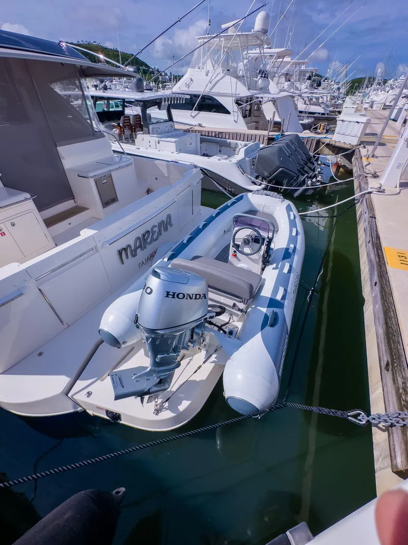 Slide: The Image of 2024 Riviera 465 SUV docked with inflatable boat, featuring Honda outboard motor. - 19