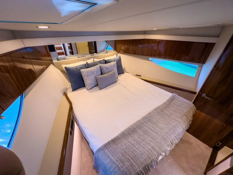 Slide: The Image of Luxurious bedroom interior of 2024 Riviera 465 SUV yacht with elegant bedding and wood accents. - 9