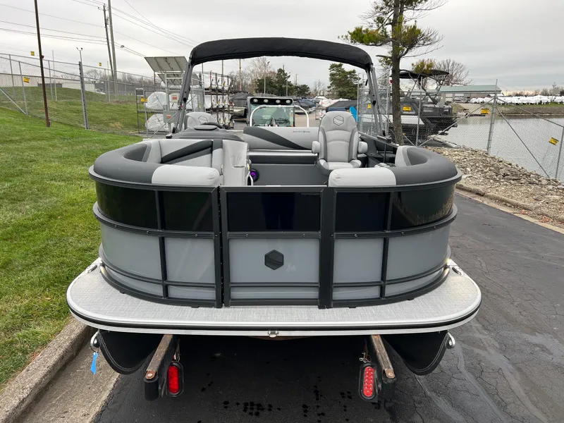 Slide: The Image of 2025 South Bay S222 UL pontoon boat, rear view, parked near water. - 2