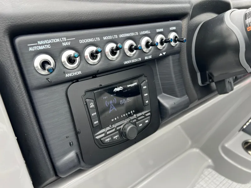 Slide: The Image of Control panel of 2025 South Bay S222 UL boat with switches and radio. - 20