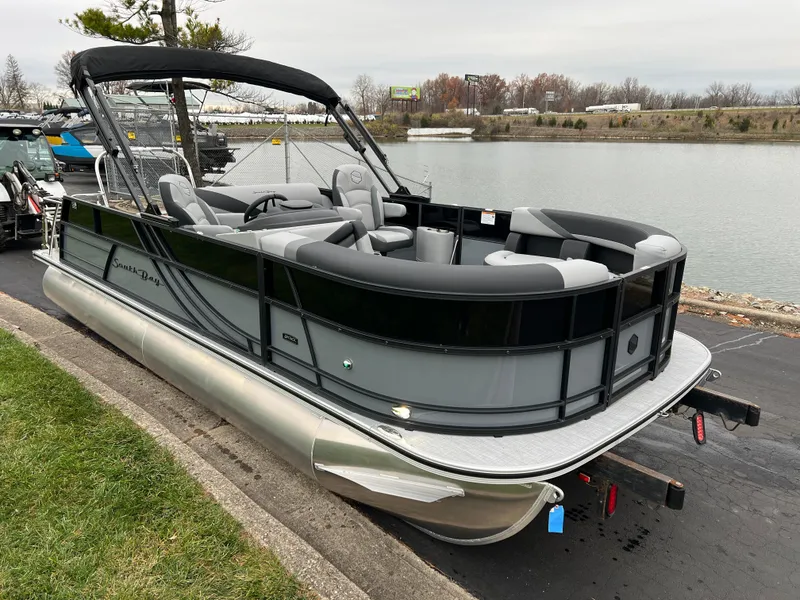 Slide: The Image of 2025 South Bay S222 UL pontoon boat docked by a lakeside. - 3