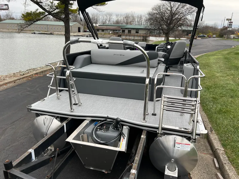 Slide: The Image of 2025 South Bay S222 UL pontoon boat docked by a lakeside. - 6