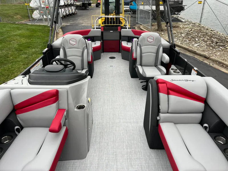 Slide: The Image of 2025 South Bay S222 RS Tri 3.0 pontoon boat interior with red and gray seating. - 10