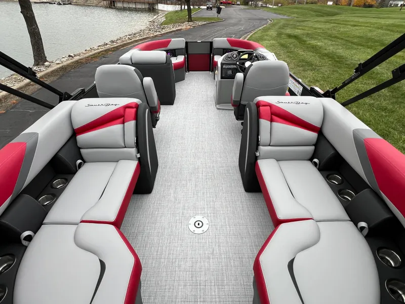 Slide: The Image of 2025 South Bay S222 RS Tri 3.0 pontoon boat interior with red and gray seating. - 13