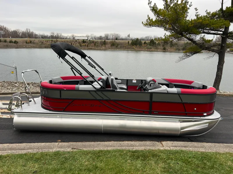 Slide: The Image of 2025 South Bay S222 RS Tri 3.0 pontoon boat by a lakeside. - 4