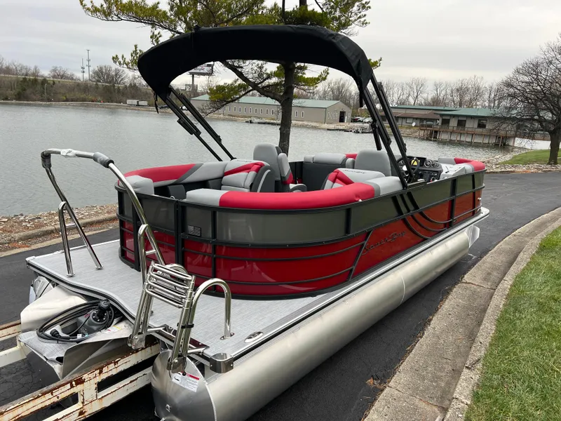 Slide: The Image of 2025 South Bay S222 RS Tri 3.0 pontoon boat docked by a lake. - 5