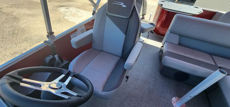 Slide: The Image of 2024 Bennington 20SVFSR pontoon boat interior with steering wheel and seating. - 20
