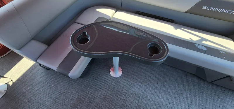 Slide: The Image of 2024 Bennington 20SVFSR boat interior with seating and table featuring cup holders. - 28