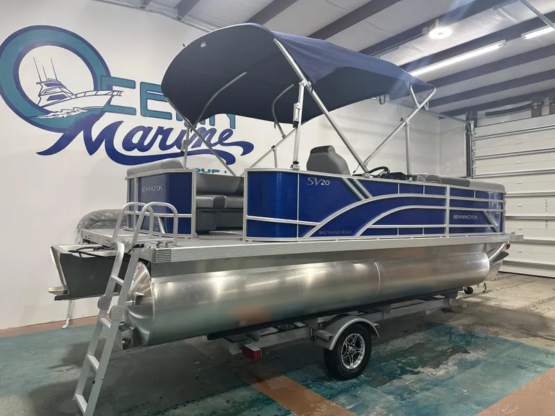 Slide: The Image of 2024 Bennington 20SVLSR pontoon boat with blue canopy in showroom. - 12