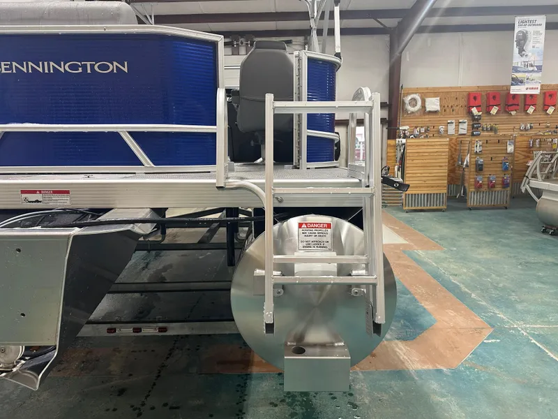 Slide: The Image of 2024 Bennington 20SVLSR pontoon boat in showroom, rear view with safety warning. - 15