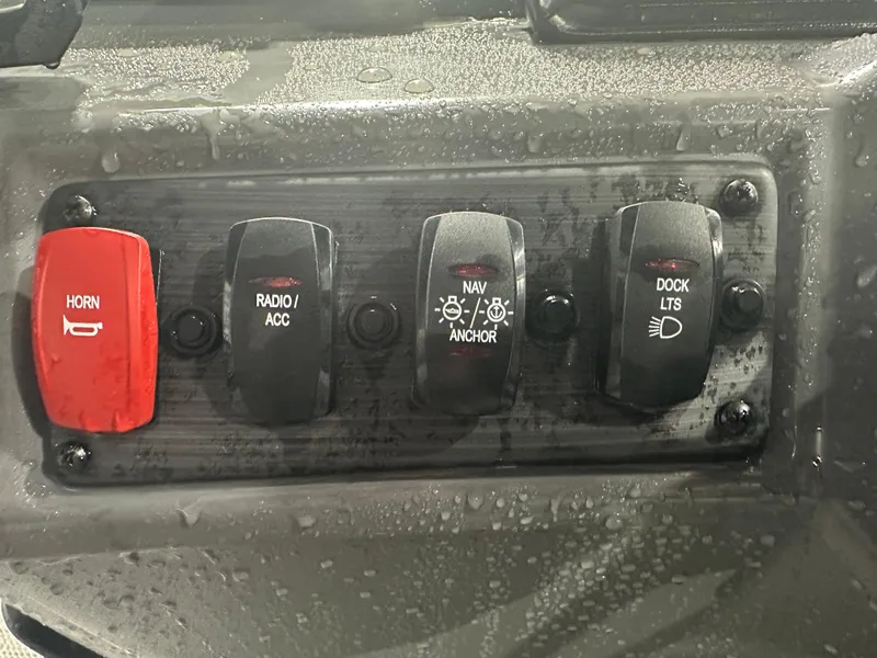 Slide: The Image of 2024 Bennington 20SVLSR boat control panel with horn, radio, navigation, and dock light switches. - 31