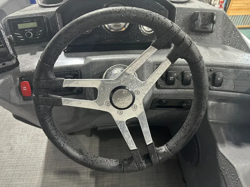 Slide: The Image of 2024 Bennington 20SVLSR steering wheel with wet dashboard controls. - 32