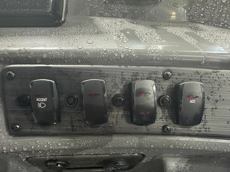Slide: The Image of Dashboard switches of 2024 Bennington 20SVLSR boat with water droplets. - 33