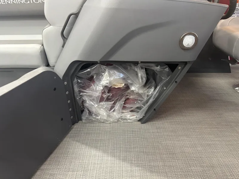 Slide: The Image of 2024 Bennington 20SVLSR boat interior storage compartment with plastic-wrapped items. - 32