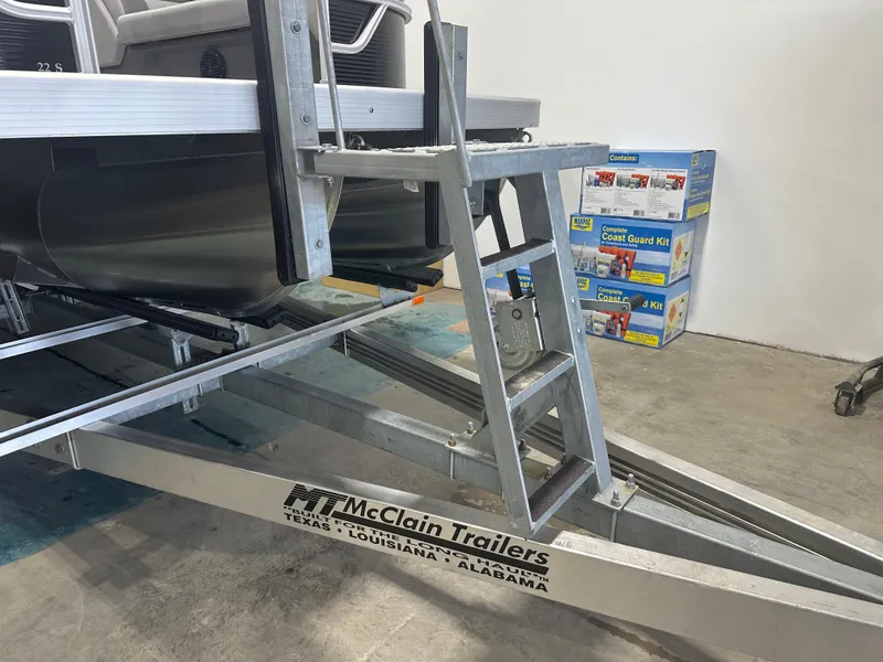 Slide: The Image of 2025 Bennington 22SSRSE boat on McClain trailer, with Coast Guard kits in background. - 11