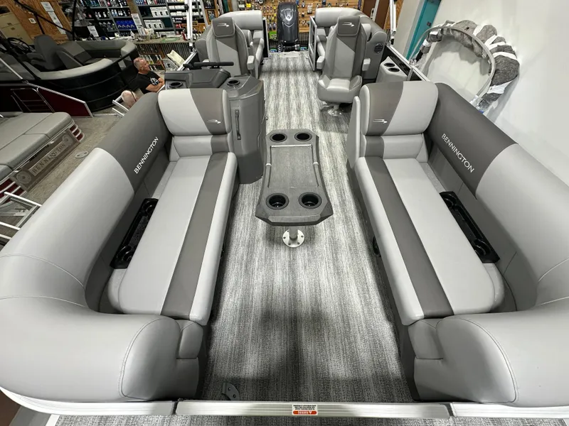 Slide: The Image of 2025 Bennington 22SSRSE pontoon boat interior with gray seating and central table. - 12
