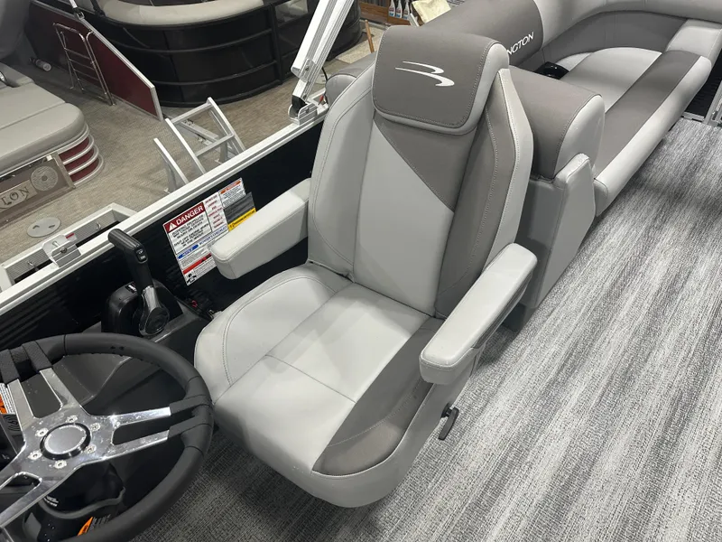 Slide: The Image of 2025 Bennington 22SSRSE boat interior with gray captain's chair and steering wheel. - 24