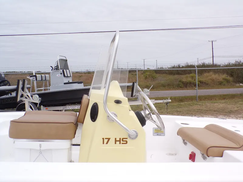 Slide: The Image of 2024 k2 Powerboats 17HS with beige seating and steering console, parked outdoors. - 3