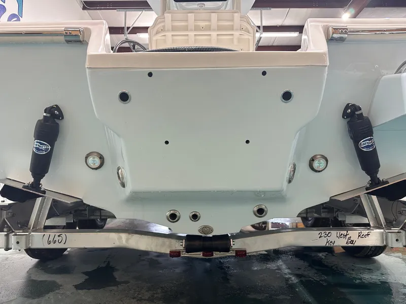 Slide: The Image of 2025 Key West 230BR boat transom view with trailer and Bennett trim tabs. - 15