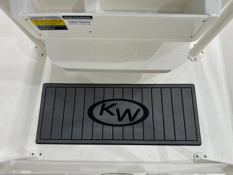 Slide: The Image of Key West 230BR 2025 boat deck with KW logo mat and capacity label. - 25