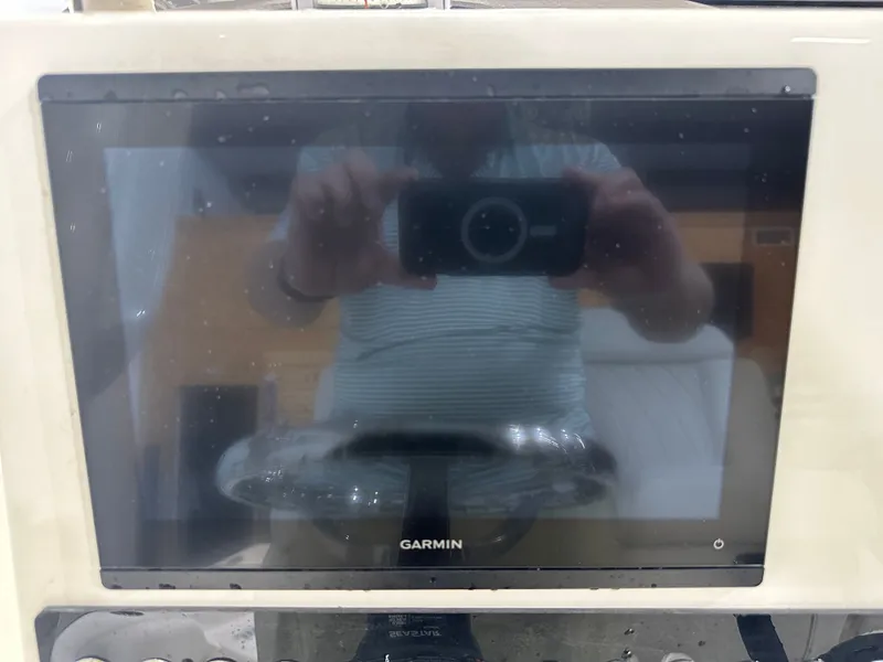 Slide: The Image of Garmin display on 2025 Key West 230BR boat dashboard, reflecting a person taking a photo. - 26