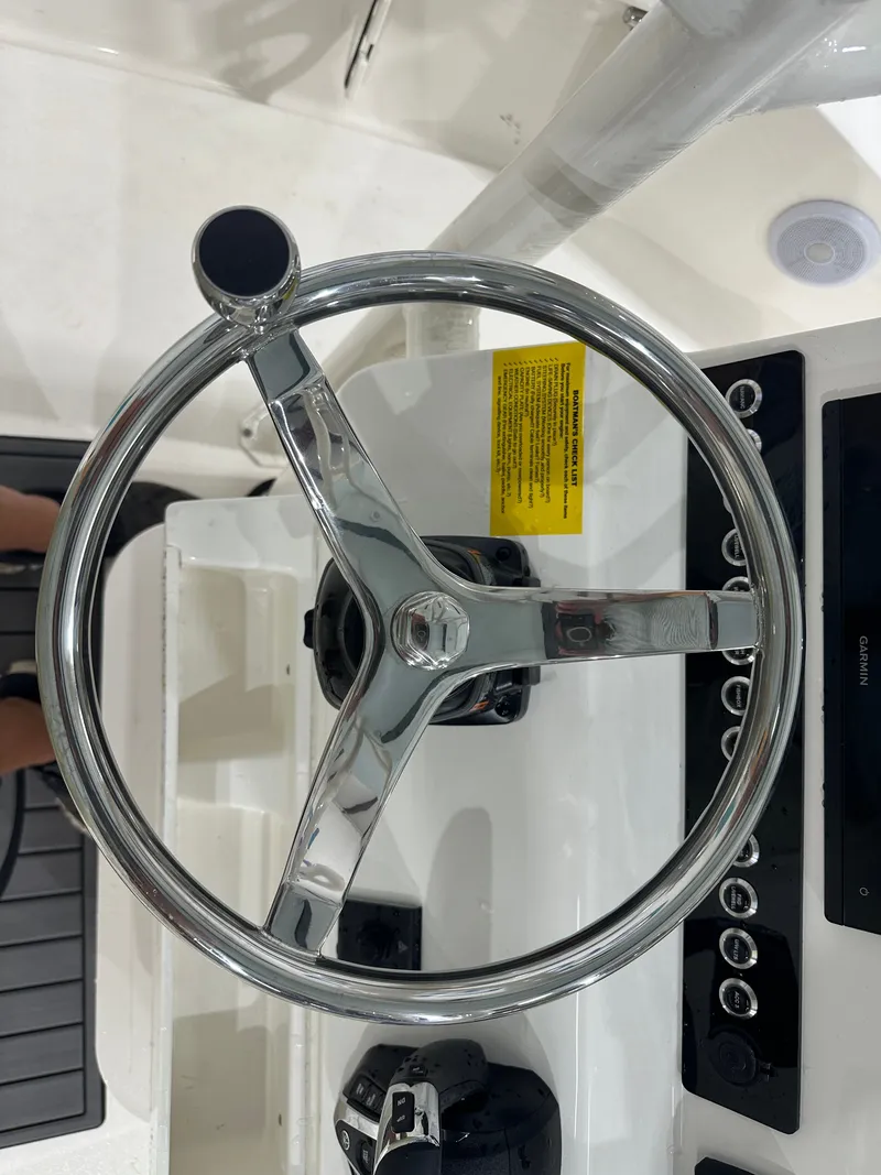 Slide: The Image of Steering wheel of a 2025 Key West 230BR boat, featuring a sleek chrome design. - 33