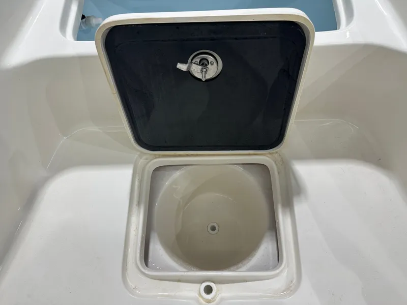Slide: The Image of Open storage compartment on 2025 Key West 230BR boat, featuring a secure latch. - 44