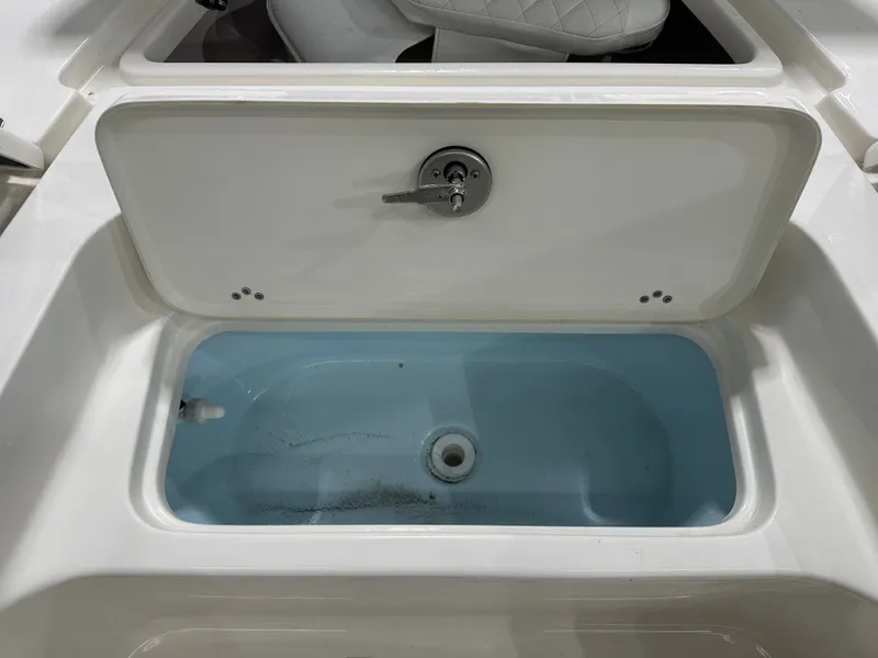 Slide: The Image of Livewell compartment on a 2025 Key West 230BR boat, featuring a white lid and blue interior. - 45