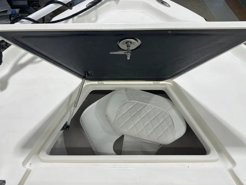 Slide: The Image of Open storage compartment on 2025 Key West 230BR boat with cushioned seat inside. - 47