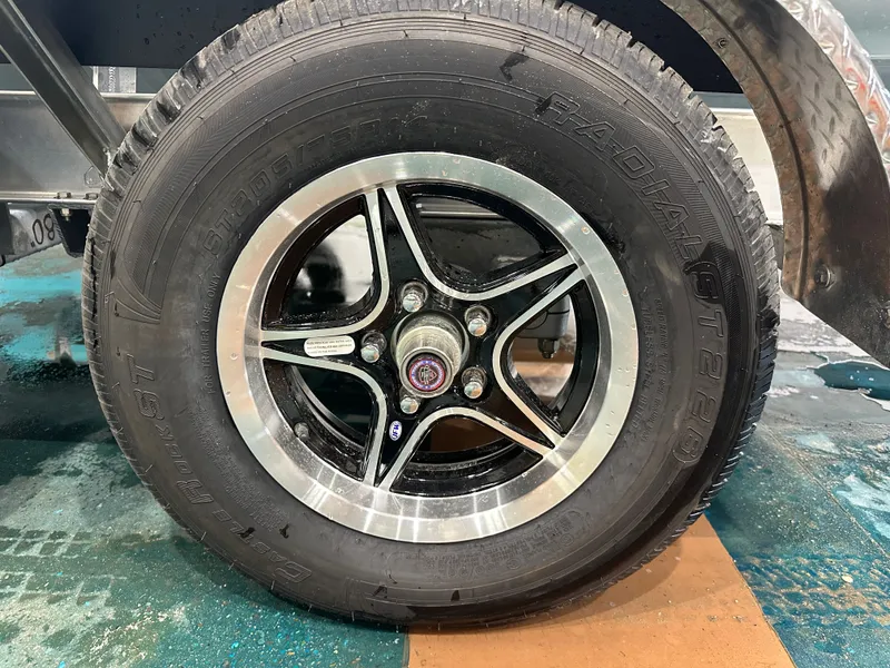 Slide: The Image of Close-up of a Key West 230BR 2025 model wheel with radial tire on a trailer. - 9