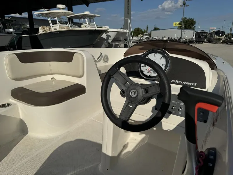 Slide: The Image of 2022 Bayliner Element E18 boat interior with steering wheel and seating. - 15