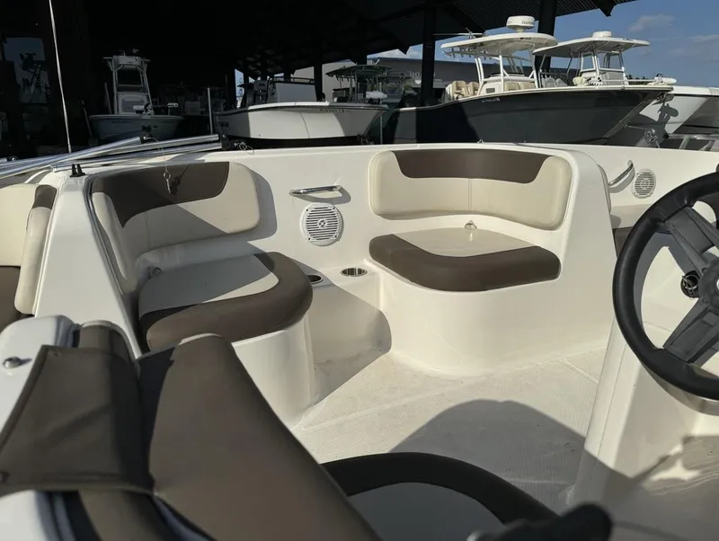Slide: The Image of 2022 Bayliner Element E18 boat interior with cushioned seating and steering wheel. - 16