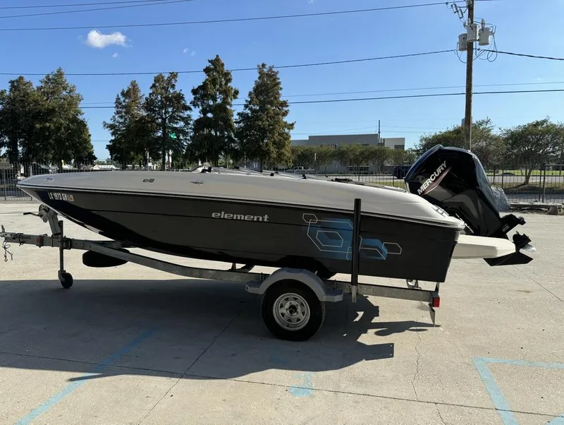 Slide: The Image of 2022 Bayliner Element E18 boat on trailer, parked outdoors under clear sky. - 3
