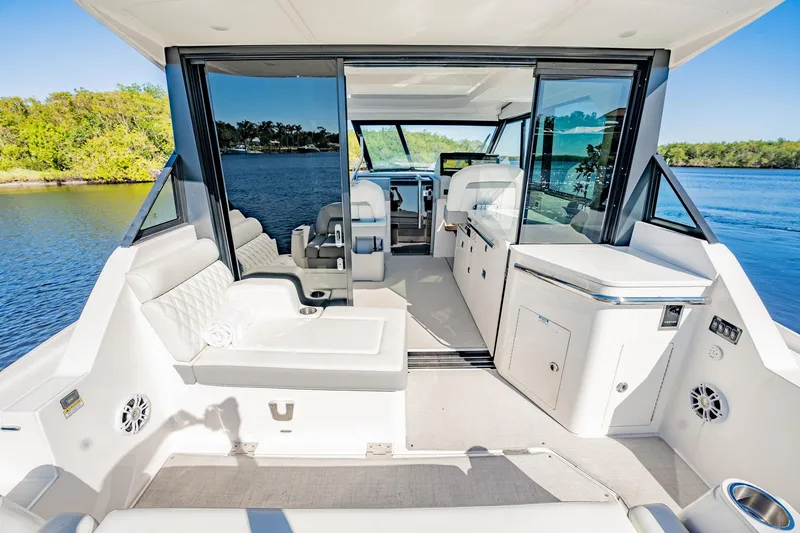 Slide: The Image of 2022 Regal 36 XO yacht interior with modern seating and sleek design on a sunny day. - 16