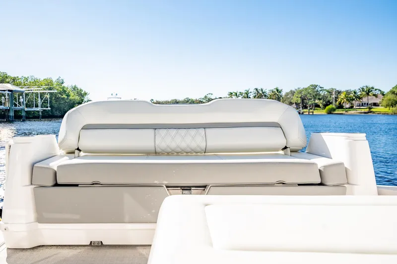 Slide: The Image of 2022 Regal 36 XO boat interior with luxurious seating by the water. - 18