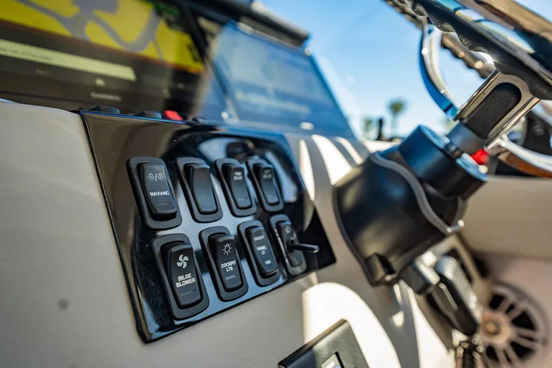 Slide: The Image of Control panel of 2022 Regal 36 XO boat with various switches and steering wheel. - 29