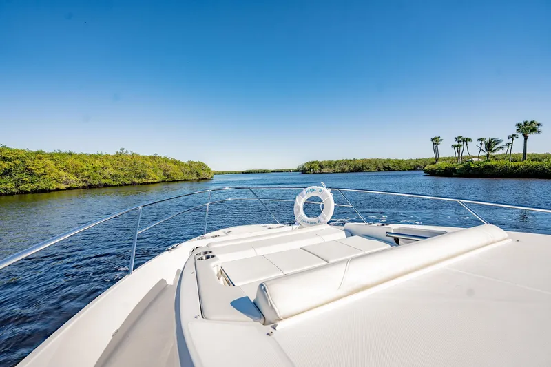 Slide: The Image of Regal 36 XO 2022 yacht cruising on a scenic river with clear blue skies. - 35