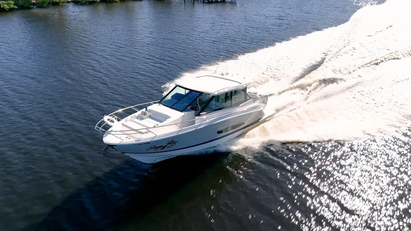 Slide: The Image of 2022 Regal 36 XO yacht cruising on a sunny day, creating a wake in the water. - 54