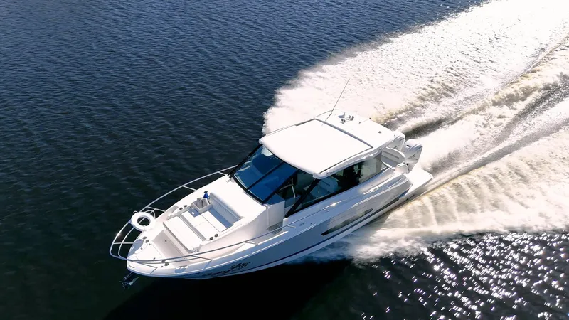 Slide: The Image of 2022 Regal 36 XO boat cruising on open water, creating a dynamic wake. - 55