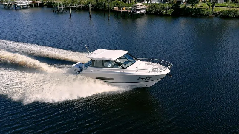 Slide: The Image of 2022 Regal 36 XO boat cruising on a serene lake. - 56