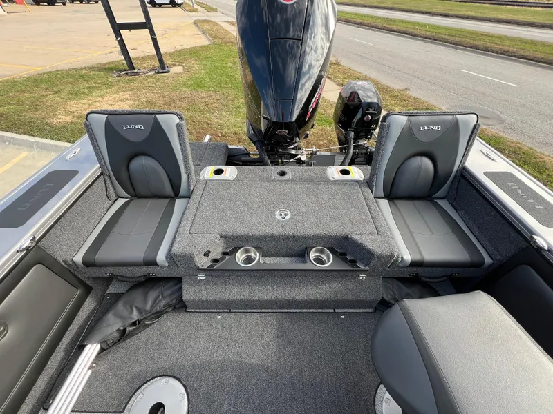 Slide: The Image of 2024 Lund 1875 Pro-V boat interior with seating and motor, showcasing modern design. - 17