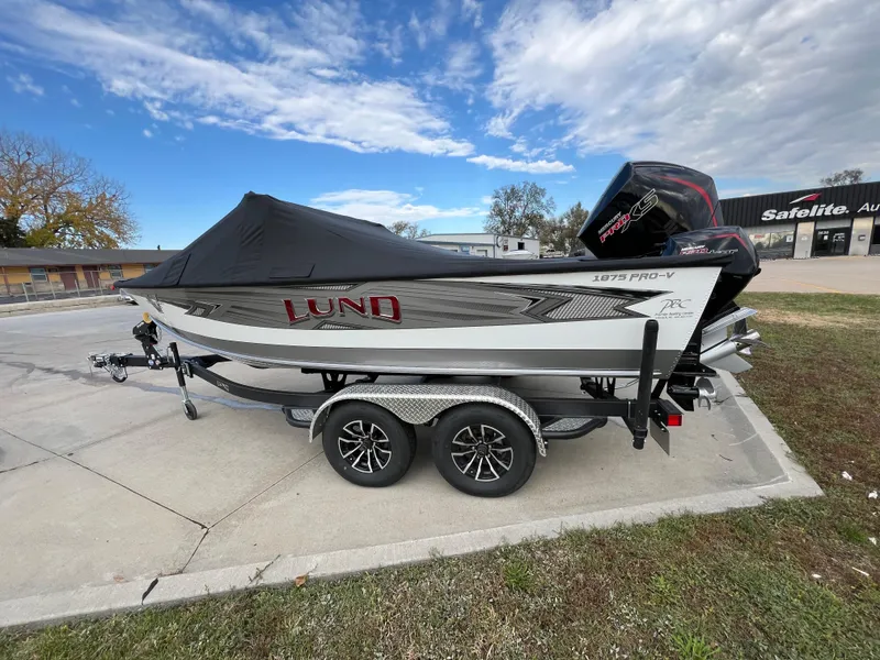 Slide: The Image of 2024 Lund 1875 Pro-V boat on trailer, covered, parked outdoors. - 4