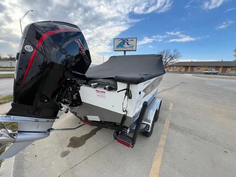 Slide: The Image of 2024 Lund 1875 Pro-V boat on trailer, covered, with powerful outboard motor. - 5